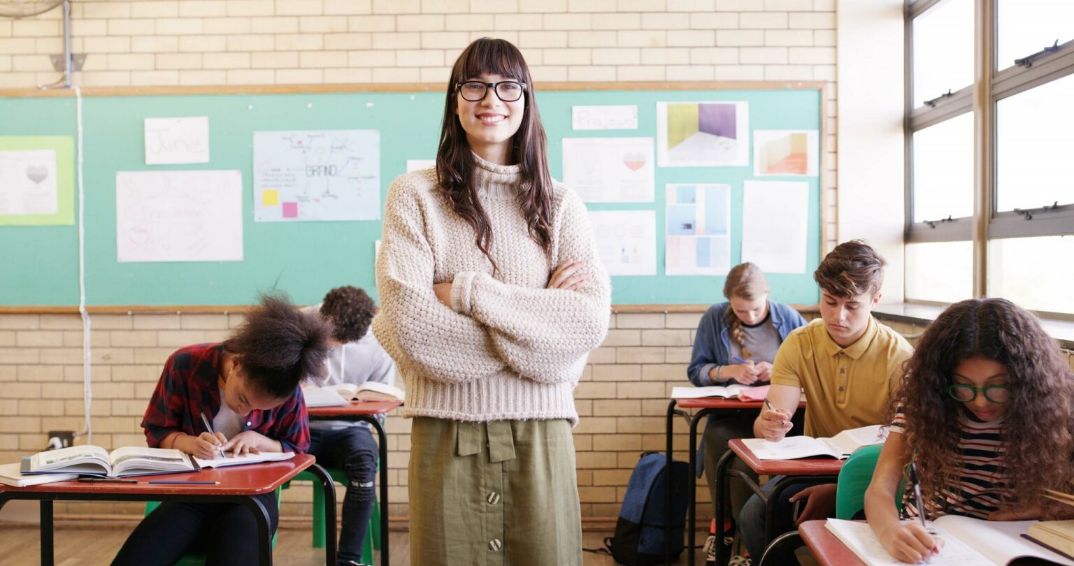 Confident teacher standing in her classroom